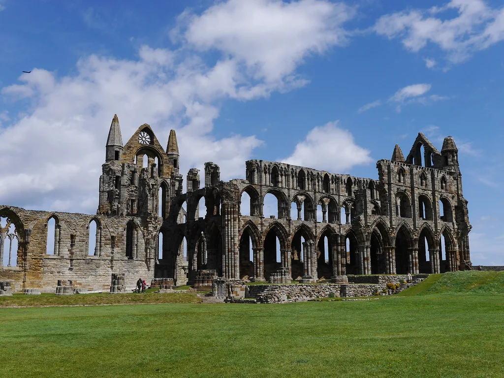 The ruins of Whitby Abbey under a blue sky.