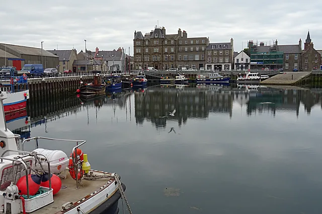 Kirkwall Harbour with boats moored below the town's waterfront buildings.