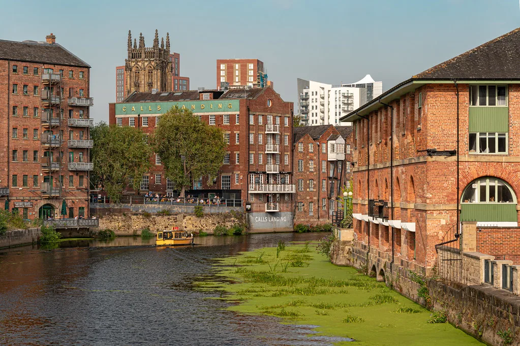 The Leeds and Liverpool Canal running past old mill buildings in Leeds.