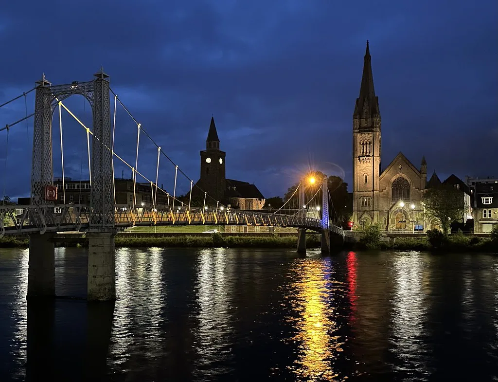 The River Ness and Inverness churches lit up at night.