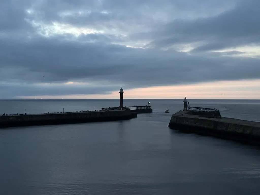 Whitby harbour piers at dusk.