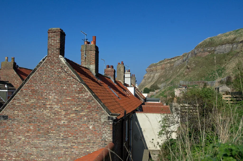 Red-roofed brick houses below the cliff in Whitby.