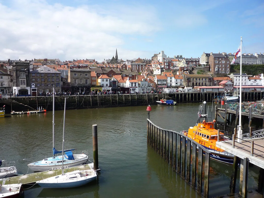 Boats in Whitby harbour below the town's rooftops.