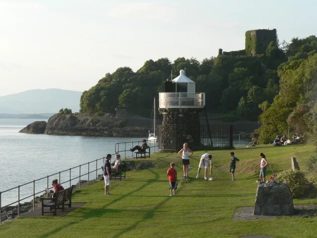 The beacon and Dunollie Castle on the shore at Oban.