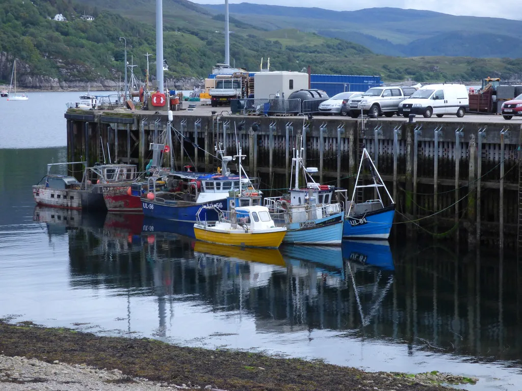 Fishing boats moored at the pier in Ullapool harbour.