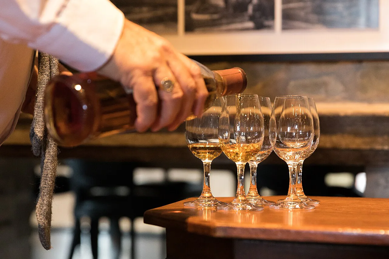 Whisky being poured into tasting glasses at Glenfiddich Distillery, Dufftown.