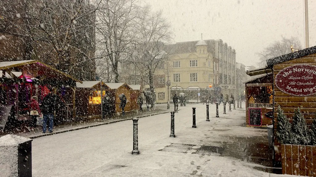 Christmas market stalls on a snowy street in Chester city centre.