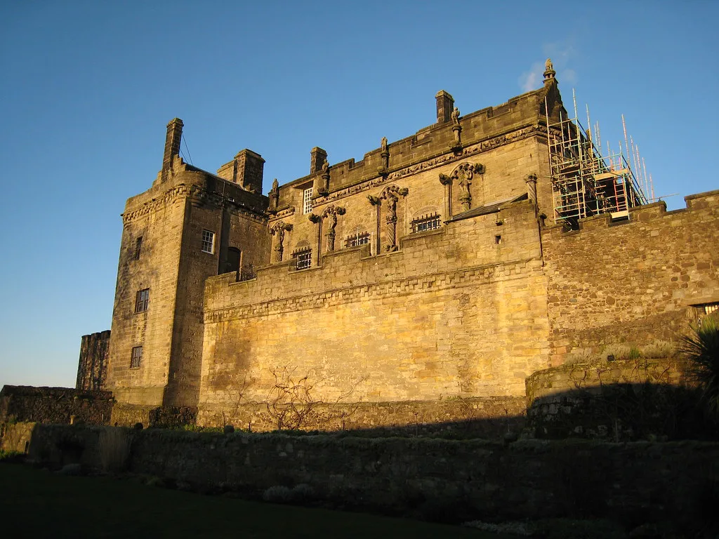 Stirling Castle's stone walls lit by evening sun.