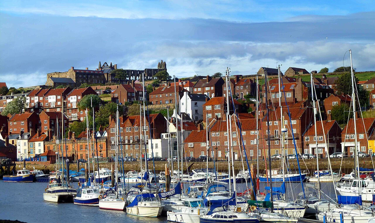 Boats in Whitby Harbour below the red roofs of Whitby.